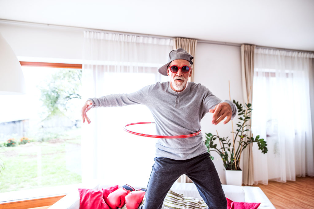 Older man hula-hooping at home!